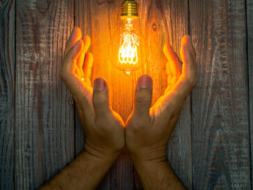 Händer som håller glödlampa