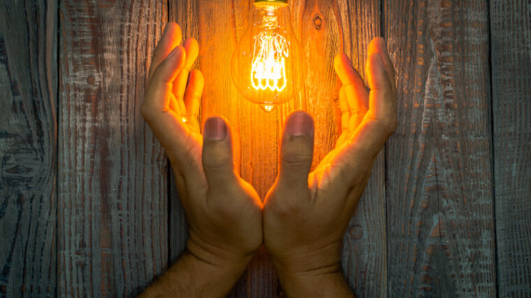 Händer som håller glödlampa