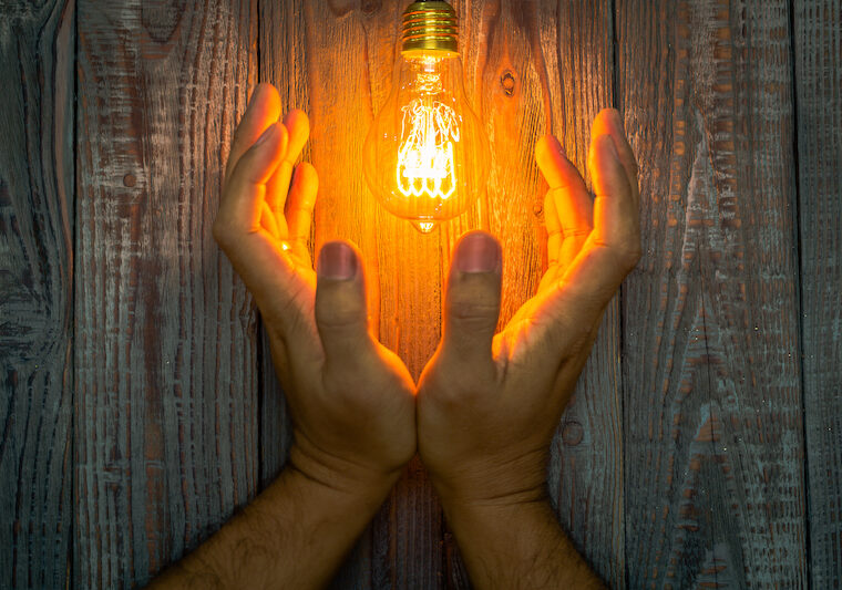 Händer som håller glödlampa