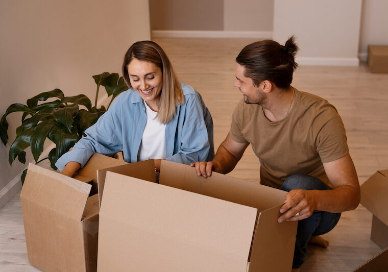 Ett par som packar flyttlådor
